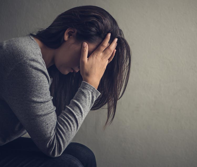 sad woman with her head in her hands